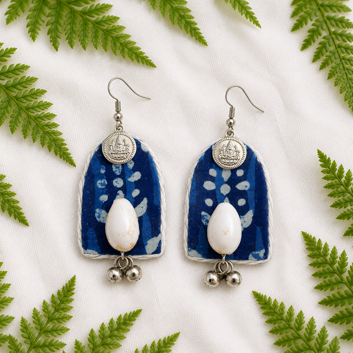Blue arch-shaped handmade fabric earrings with cowrie shells, silver charms & ghungroos by artisian touch