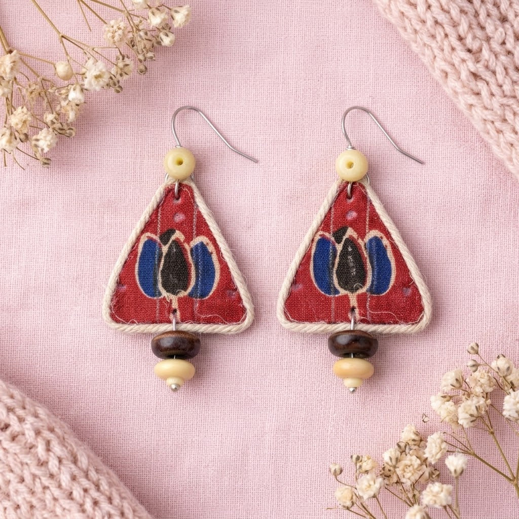 Triangular earrings with lotus floral design on a pink background with wooden beads