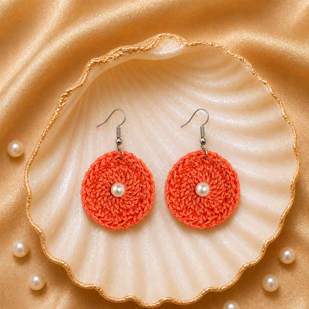 Pair of orange crochet earrings with pearl centers on a shell with pearls artisian touch