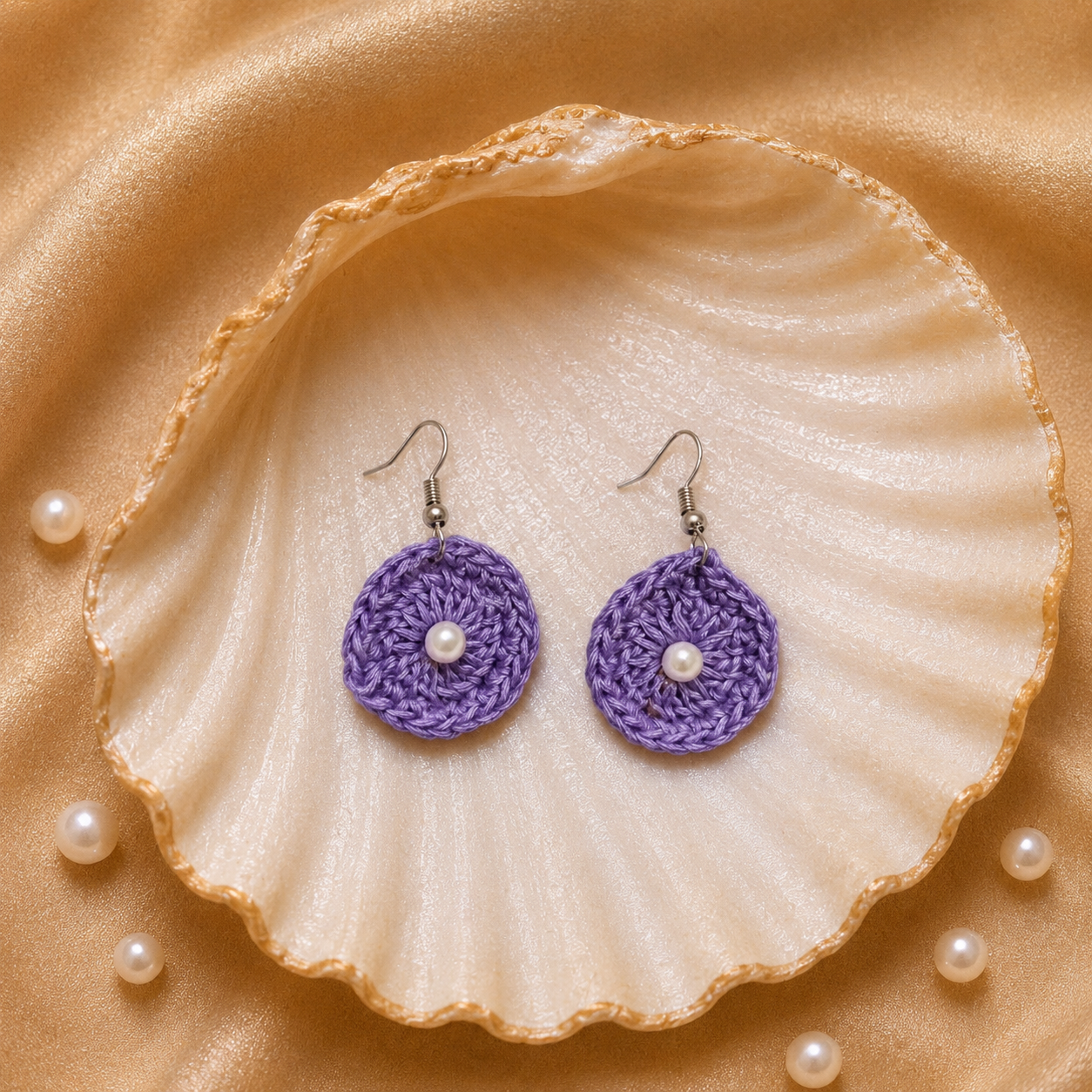 Purple round crocheted earrings with pearl centers on a seashell with pearls around artisian touch